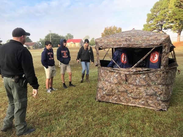 Students looking at a deer stand